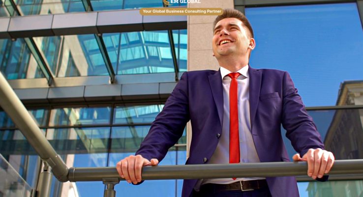 Satisfied business professional in a suit standing on an office balcony and looking across the city skyline, representing international business growth and corporate strategy.